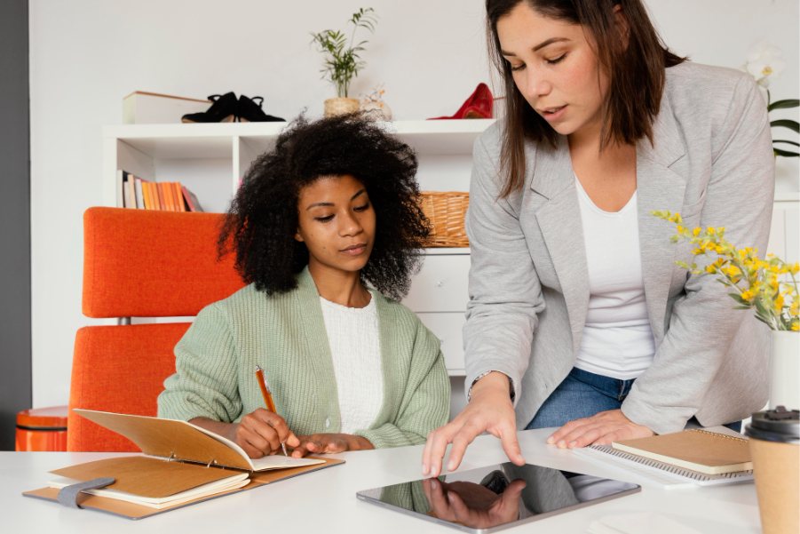 Two colleagues working through notes together at a desk